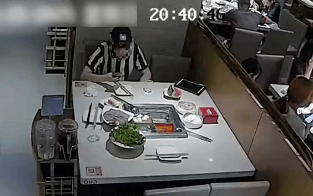 警方翻看CCTV發現其疑似存在故意向菜品內丟蟑螂的動作。 警方翻看CCTV發現其疑似存在故意向菜品內丟蟑螂的動作。