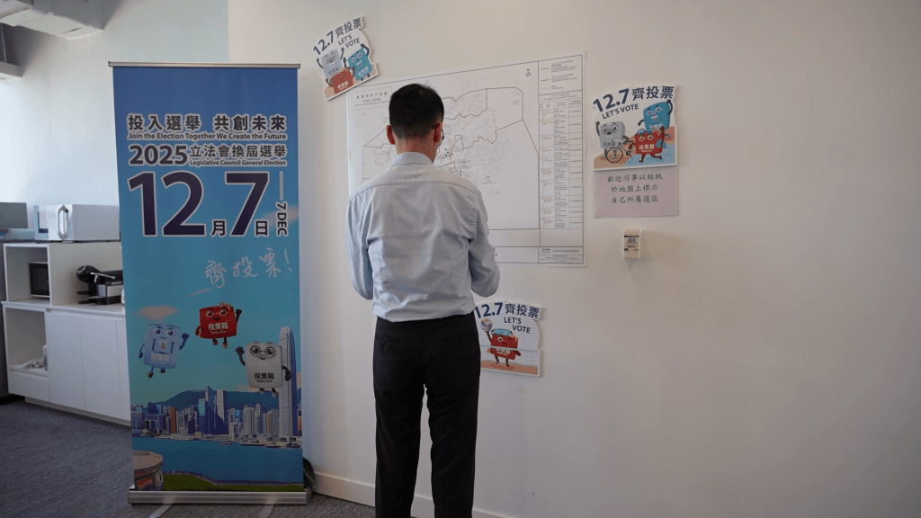 特首政策組同事一個接一個到地圖前,以藍色貼紙貼出自己所屬選區。 特首政策組同事一個接一個到地圖前,以藍色貼紙貼出自己所屬選區。