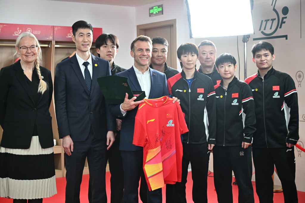 馬克龍與中國隊球員合影。中新社