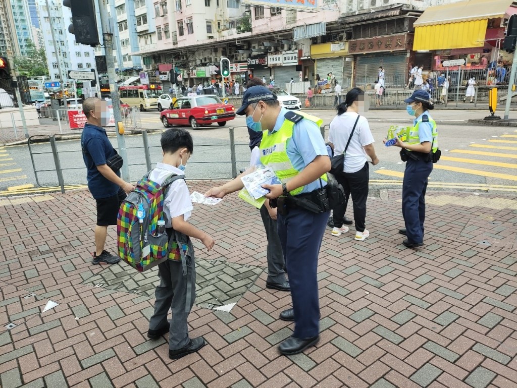 警員派發宣傳單張,呼籲學童及家長善用過路設施小心過馬路。 警方圖片