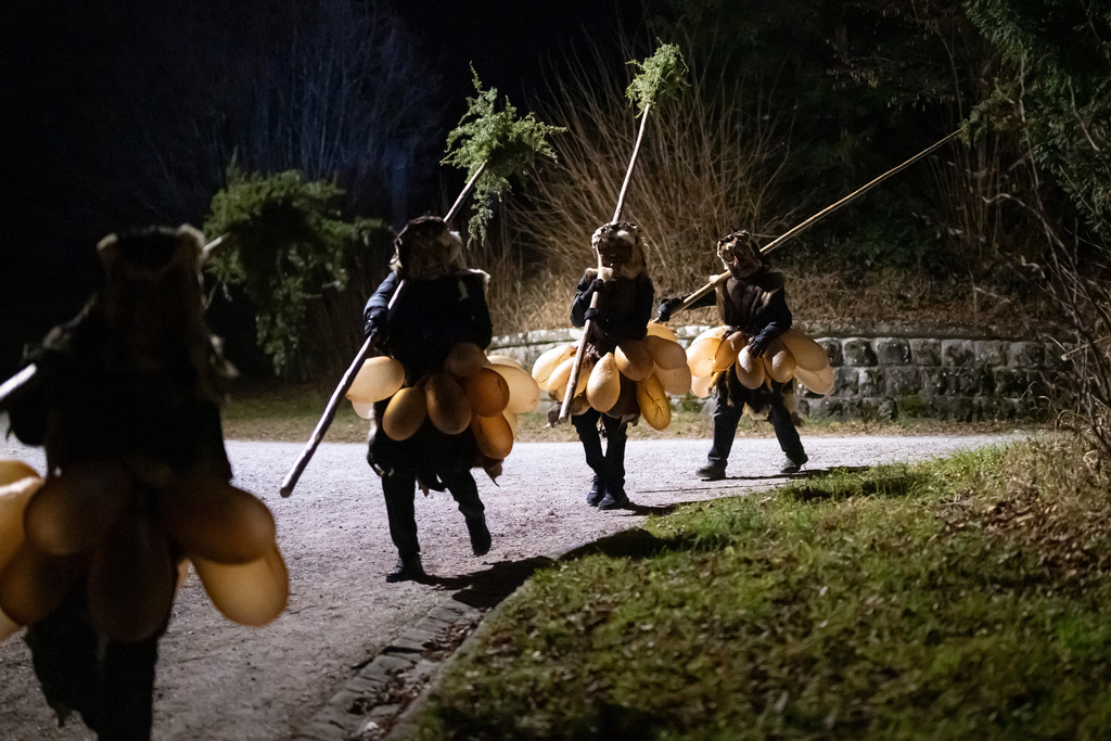2025年12月31日星期三，在瑞士勞彭，手持長柄杜松木掃帚、戴著恐怖木製面具、身穿充氣豬膀胱服的「掃帚人」（Baesemanne）正在為第102屆傳統的「Achetringele」遊行做準備。這場遊行旨在驅趕邪靈，迎接新年。美聯社