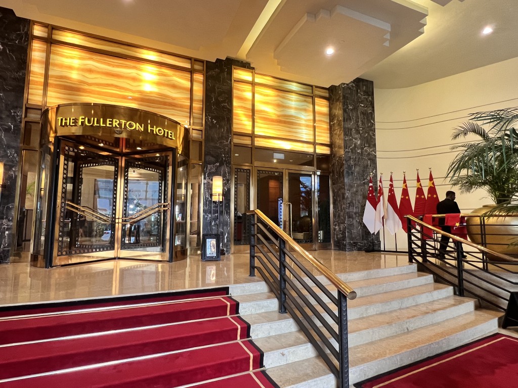 代表團將入住的富麗敦酒店，門外掛有新加坡國旗及香港區旗。（郭詠欣攝）