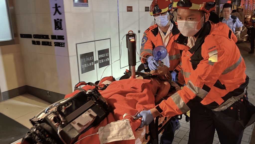 救護人員一邊為男傷者使用自動心肺復甦機,一邊將他緊急送院。黎志偉攝 救護人員一邊為男傷者使用自動心肺復甦機,一邊將他緊急送院。黎志偉攝