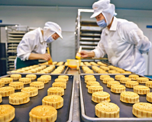 ■工人在山東省濱州市高新區一家食品企業車間生產月餅等工作。
