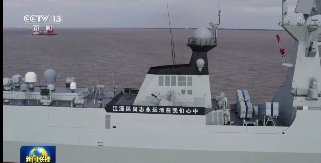 軍艦黑底白字橫幅上寫著「江澤民同志永遠活在我們心中」。