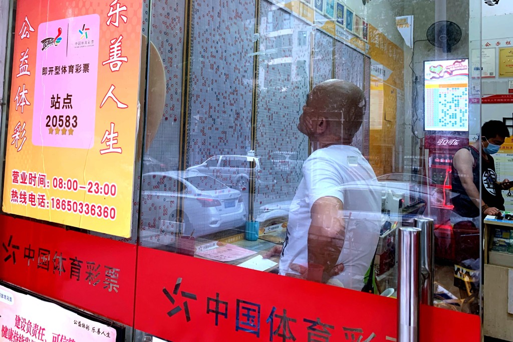 不少人買彩票希望能一朝發達。中新社