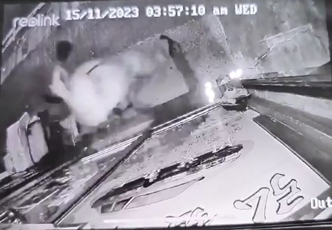 鸭舌帽男子用硬物砸爆地产铺玻璃。闭路电视片段截图