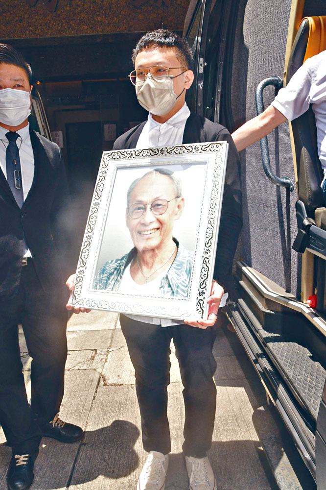 黃榮璋捧黃樹棠遺照，送爸爸最後一程。