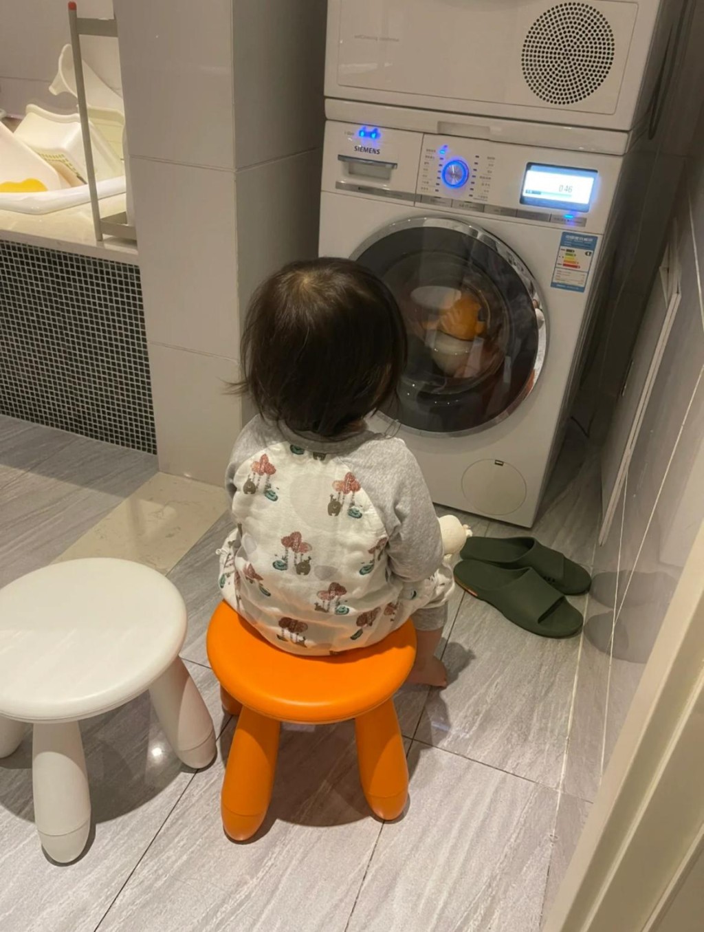 妈妈于网上分享女儿背影照片，见她默默地坐在洗衣机前等待，原来是等待「它」！（图片来源：柚柚好忙 @小红书）
