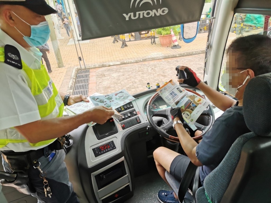 警員派發宣傳單張,提醒區內的校巴及保母車司機安全駕駛。 警方圖片