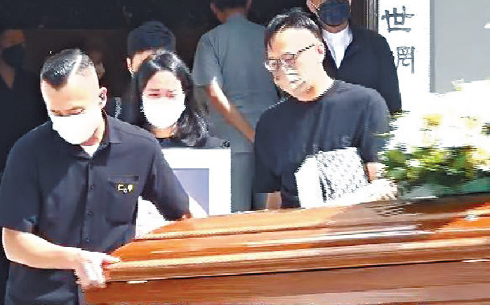 ■曾慕雪捧着父親曾江的遺照，步出教堂。
