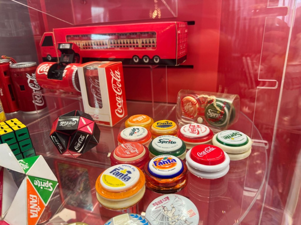 「開啟尋樂趣之旅」，展出歷代「可口可樂」的瓶身設計，以及不同年代推出的特色紀念品，如可口可樂搖搖。（圖片來源：《親子王》）