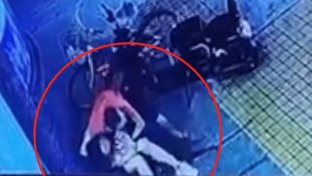 紅衣男雙手疑似放在女子胸部猥褻。