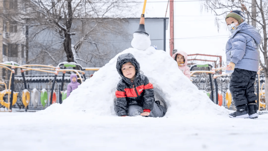 11月26日，小朋友在長春市一所幼兒園內玩雪。新華社