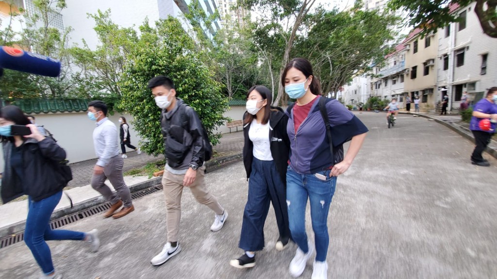 何忻諾(白衫黑外套者)被押解返住所搜查。