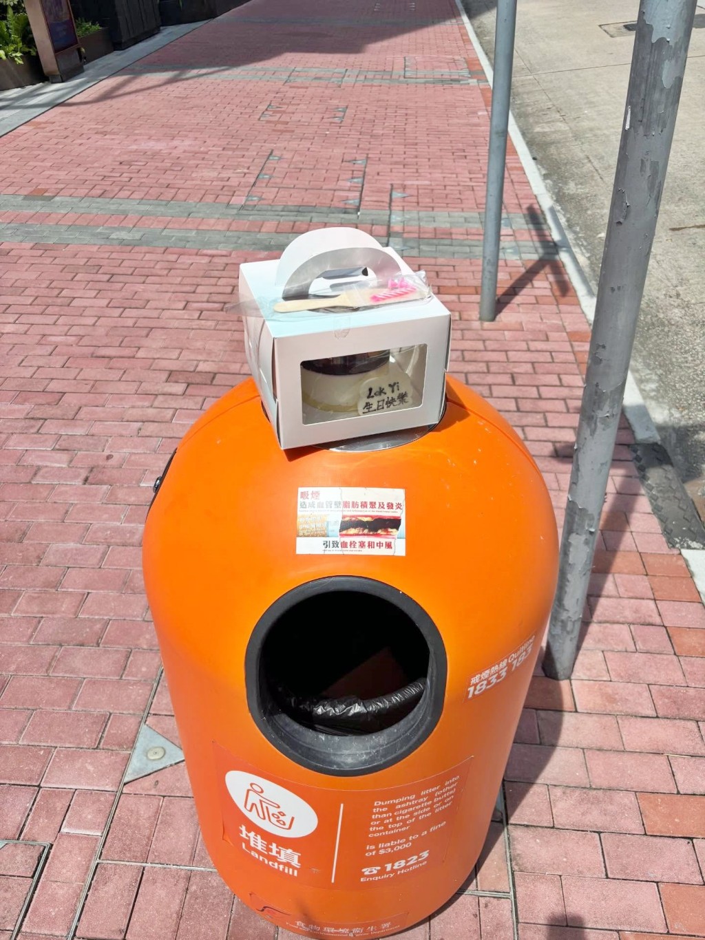 相中慘遭擱於垃圾桶頂，在日光下置於紙盒 內的蛋糕，寫有「LokYi生日快樂」字樣。如 此孤獨的生日蛋糕，好比一封正在溶化的情書 。回應的網民看過圖片後，有人指「我…第一 次見依款垃圾桶」。Threads截圖