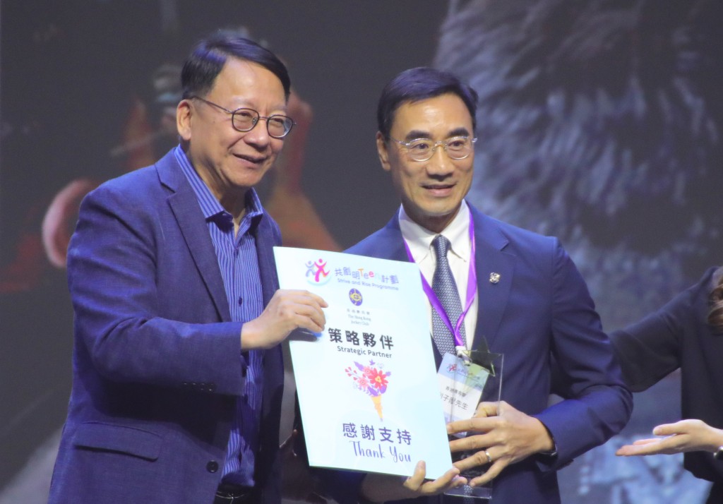 政务司司长陈国基（左）向香港赛马会主席利子厚（右）颁发「策略夥伴大奬」证书及奬杯，感谢马会对「共创明『Teen』计划」的支持。