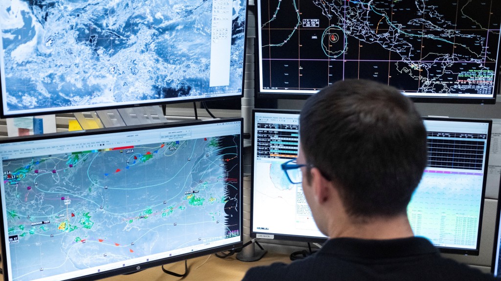 NOAA 氣象學家正在注視監測器。 路透社 NOAA 氣象學家正在注視監測器。 路透社