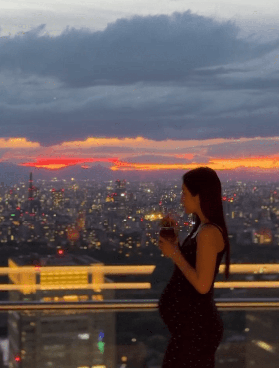 黃碧蓮在東京的頂級酒店露台，以醉人日落作背景，手持飲品輕撫孕肚，畫面唯美，散發著滿滿的幸福感。