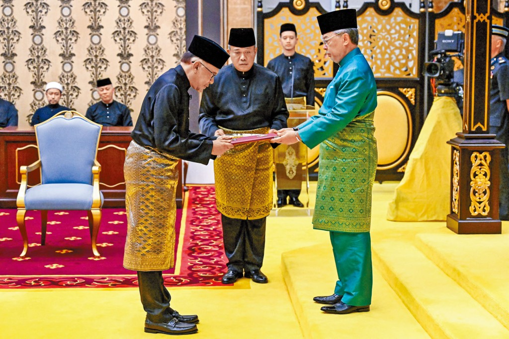 安華（左）周四在國家元首蘇丹阿都拉面前，宣誓就任首相。