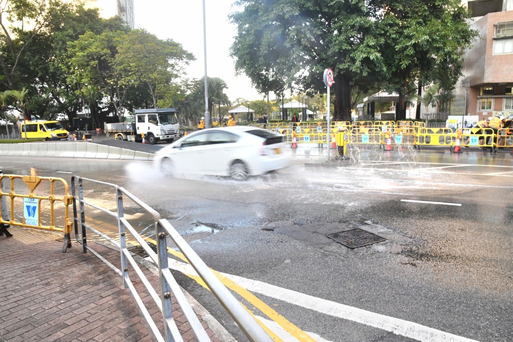 私家車穿過水氹時濺起大量水花。徐裕民攝