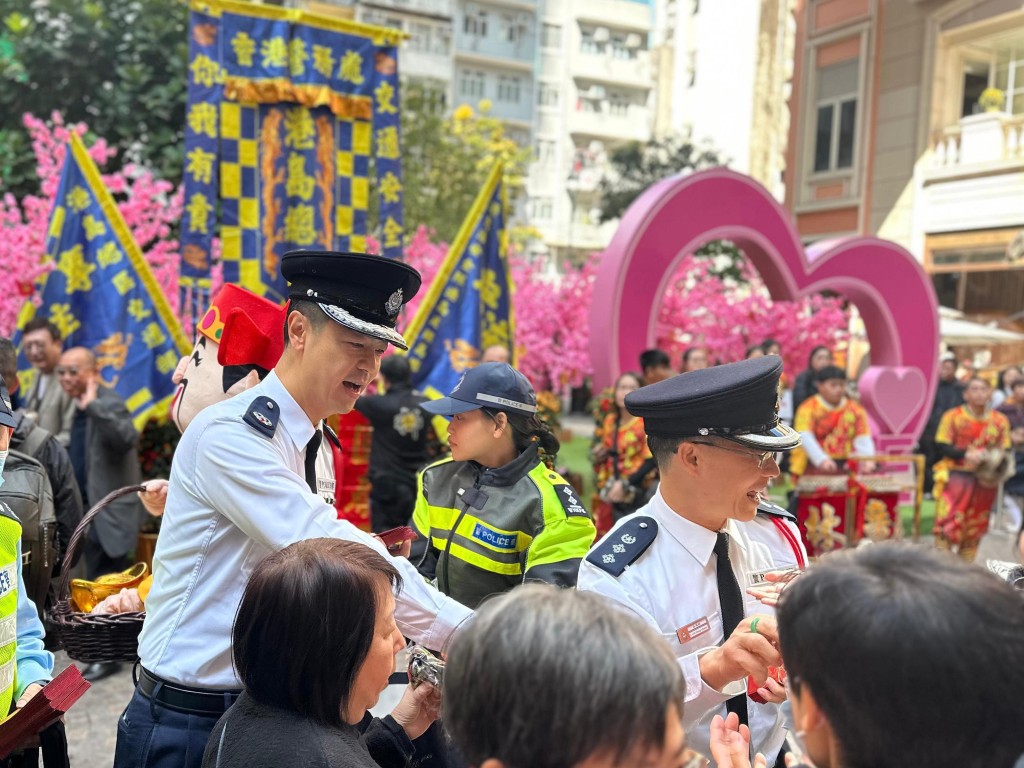 港島總區指揮官郭嘉銓(左)及港島總區副指揮官林鴻釧(右)於灣仔利東街向市民派發紀念品。