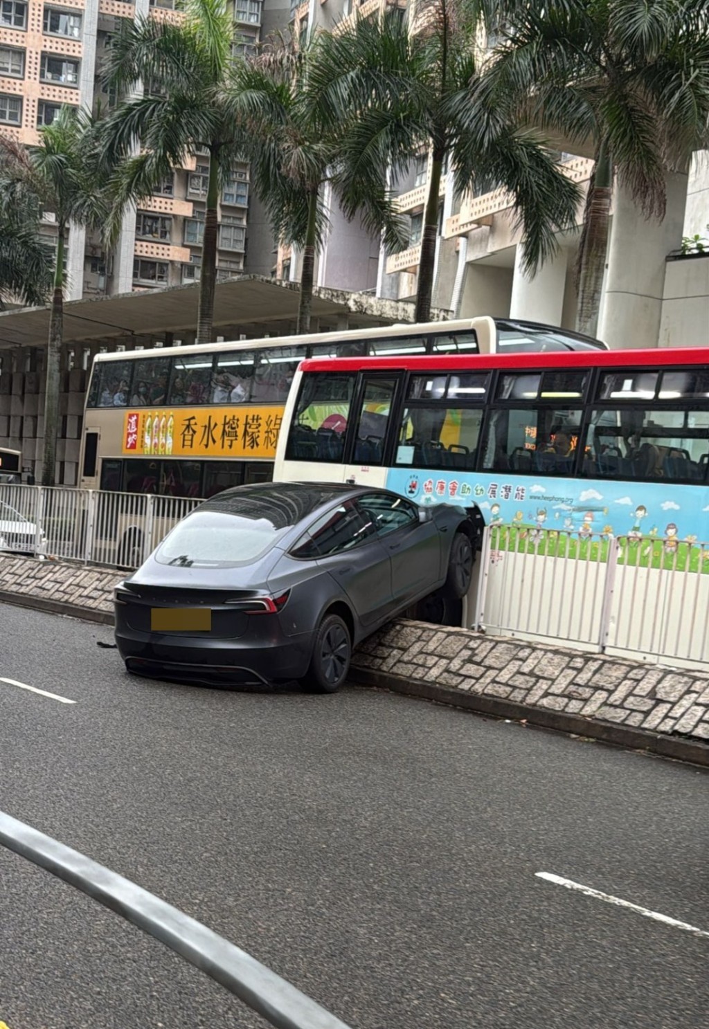 私家車剷上石壆撞爛鐵欄再撞旅遊巴右車身。fb車cam L（香港群組）圖片
