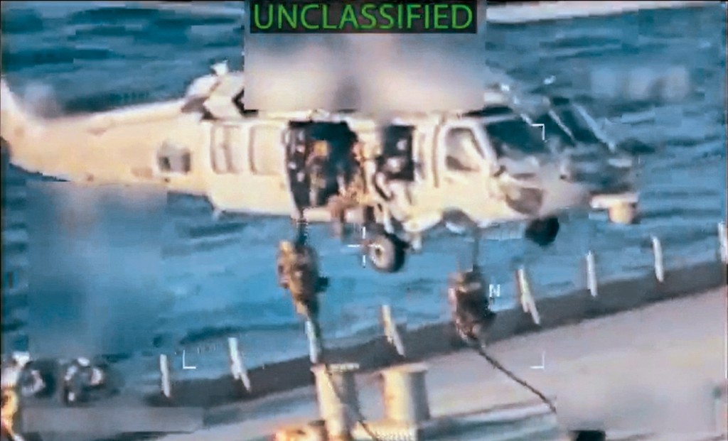 美司法部長發布影片顯示，美軍從懸停的直升機游繩降落到油輪甲板。 