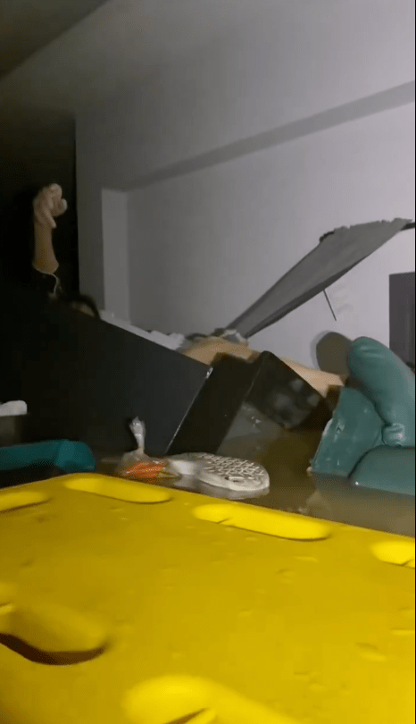 救援人員發現一個漂浮於急流中的冰箱，微弱燈光下，一名年約50歲的婦人虛弱地舉手示意求救。X@Mr_Whathapened