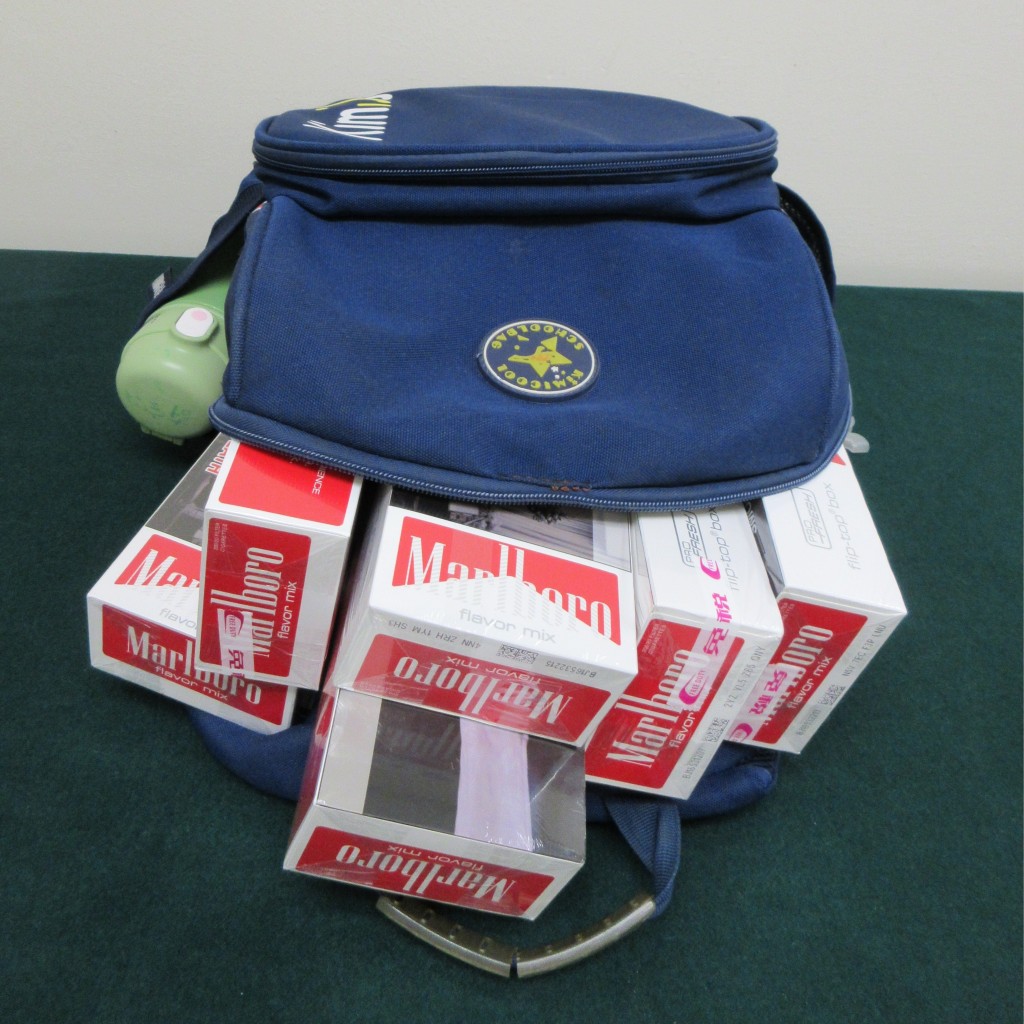 女子利用其同行儿童所携带的背包收藏未完税香烟。海关图片