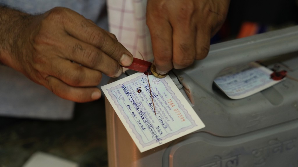 工作人员为上锁的电子投票机挂上标签。 美联社
