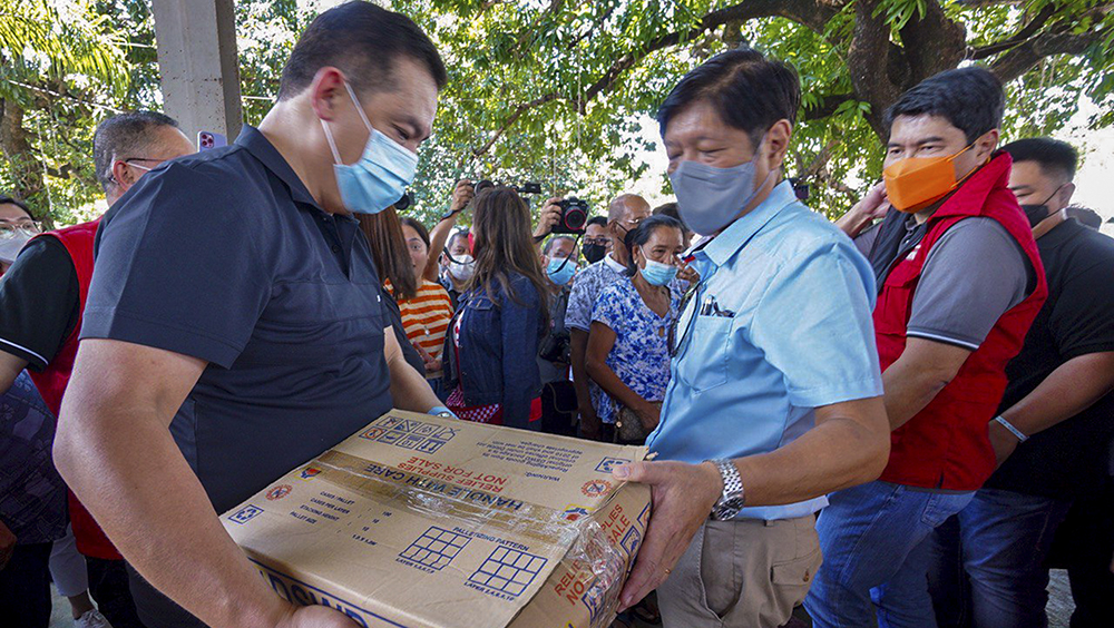 菲律賓總統小馬可斯視察災情，派發救濟包給災民。AP