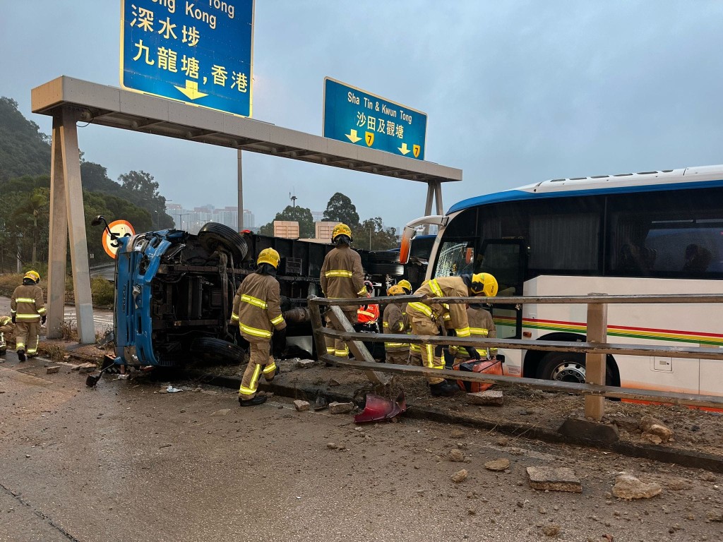 密斗貨車先撞上石壆，繼而向右翻側，整架車橫亙石壆之上，救援人士在現場為鐵騎士治理。黎志偉攝