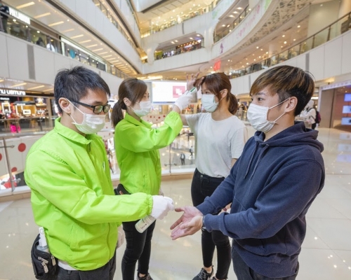 新地關懷大使為顧客 探熱及提供消毒搓手液。新地圖片