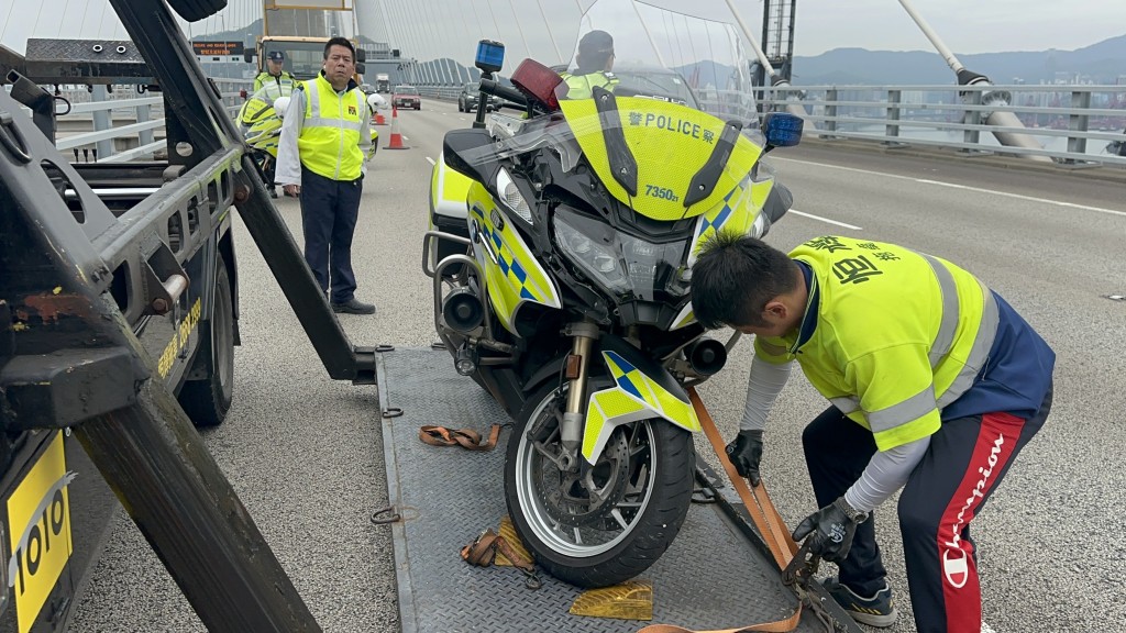 警察电单车与私家车相撞，警员脚部受伤由救护车送院。梁国峰摄