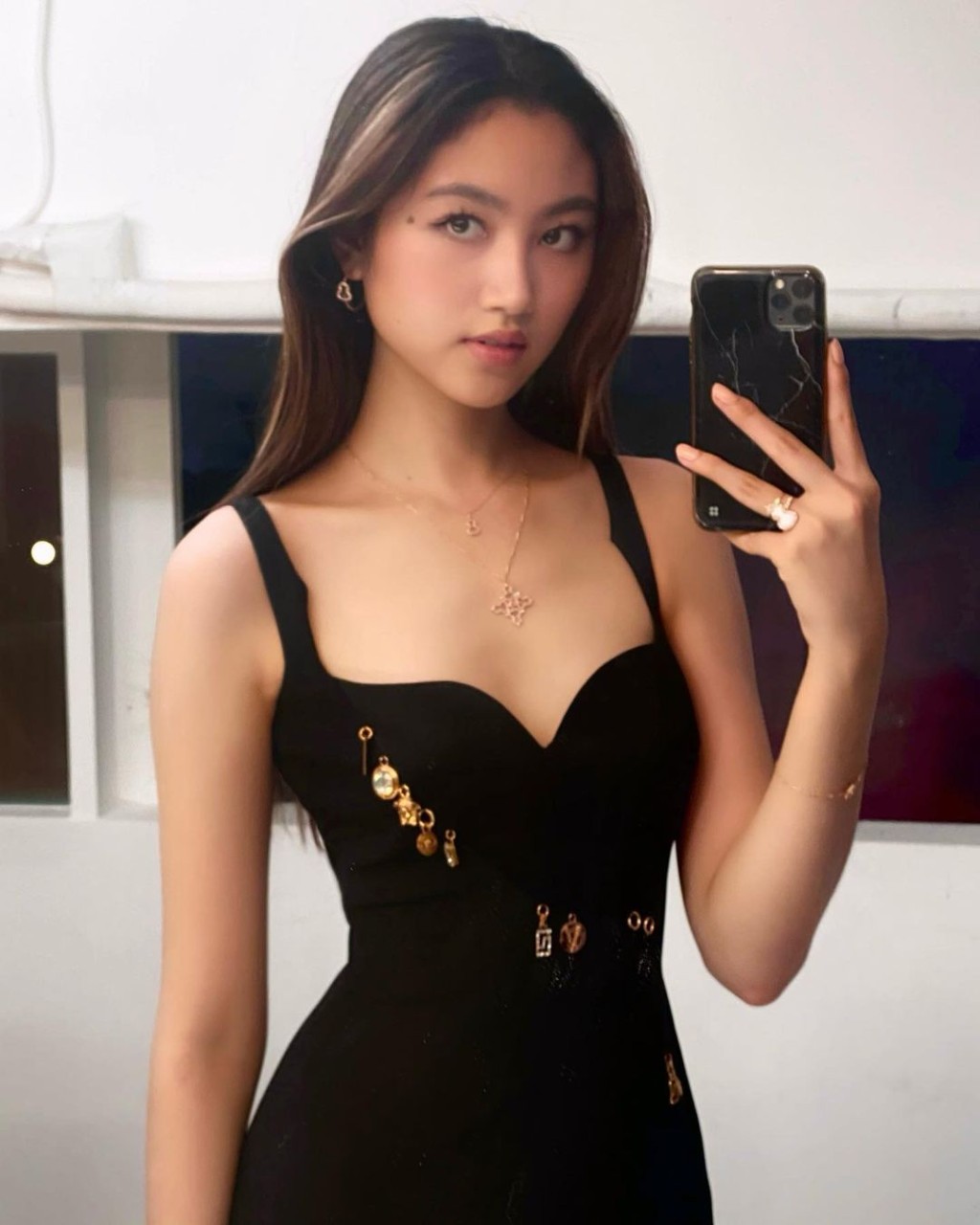 黑色吊起低胸裝，展現女性化一面。