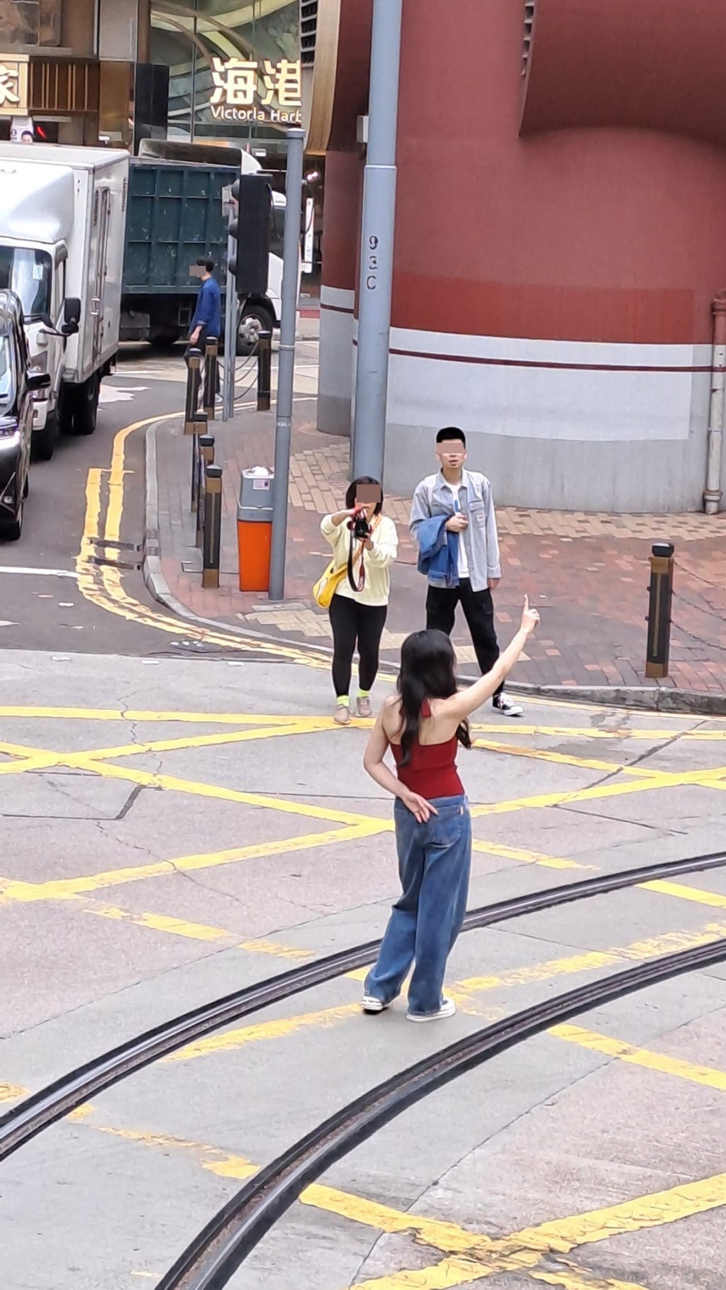 露背女站於路中的電車軌指手畫腳。網圖