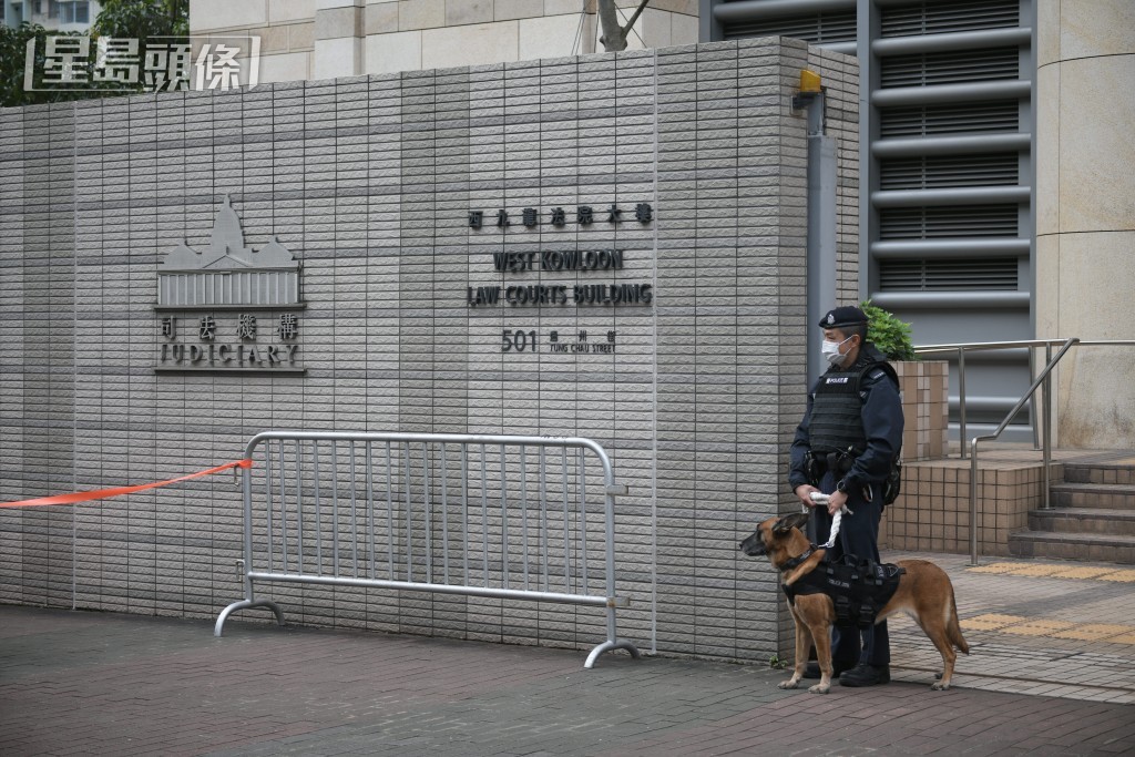 案件今早在西九龍裁判法院開審，警員攜同警犬在門外站崗。陳浩元攝