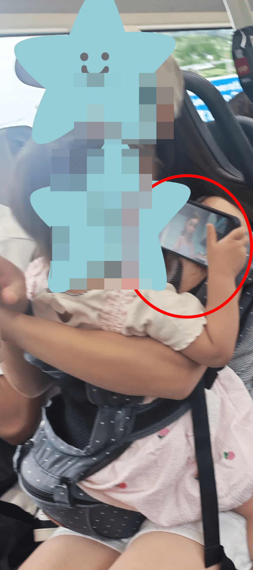 該名手抱女嬰的雙手正緊緊持著一部智能電話（帖文截圖）