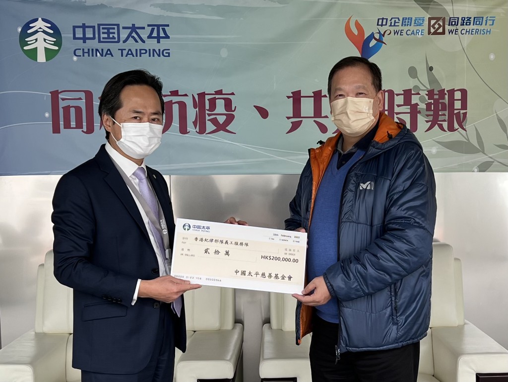 中國太平選委會(商界三)委員姚來文代表中國太平向紀律部隊義工隊主席麥錦輝捐贈支票。
