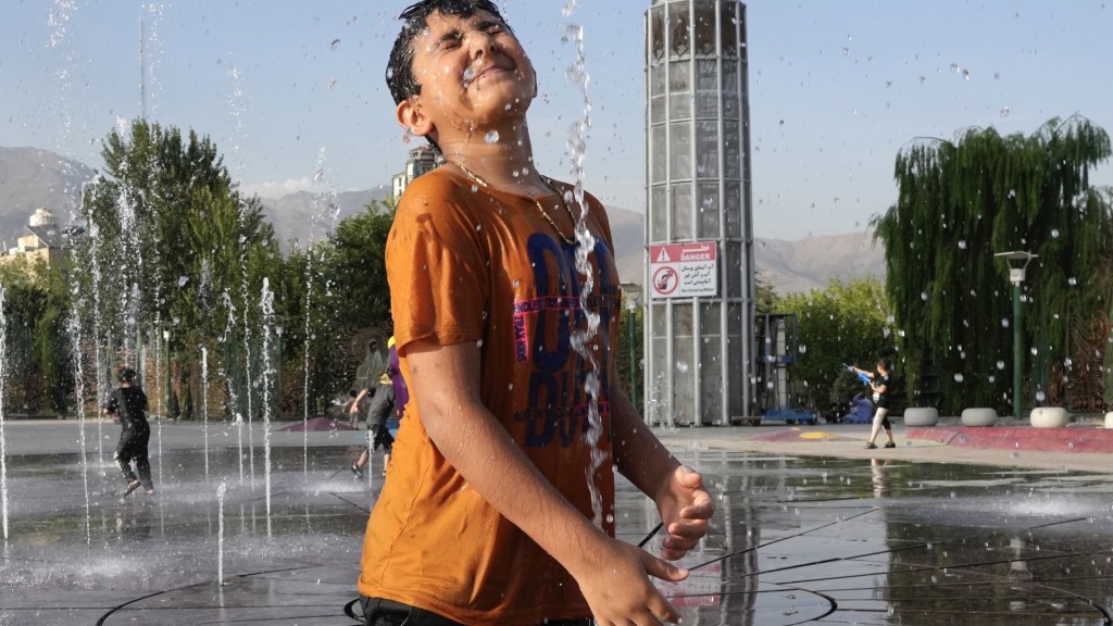 德黑兰周二录得摄氏38度，小朋友在易卜拉欣公园的喷泉玩水消暑。 美联社
