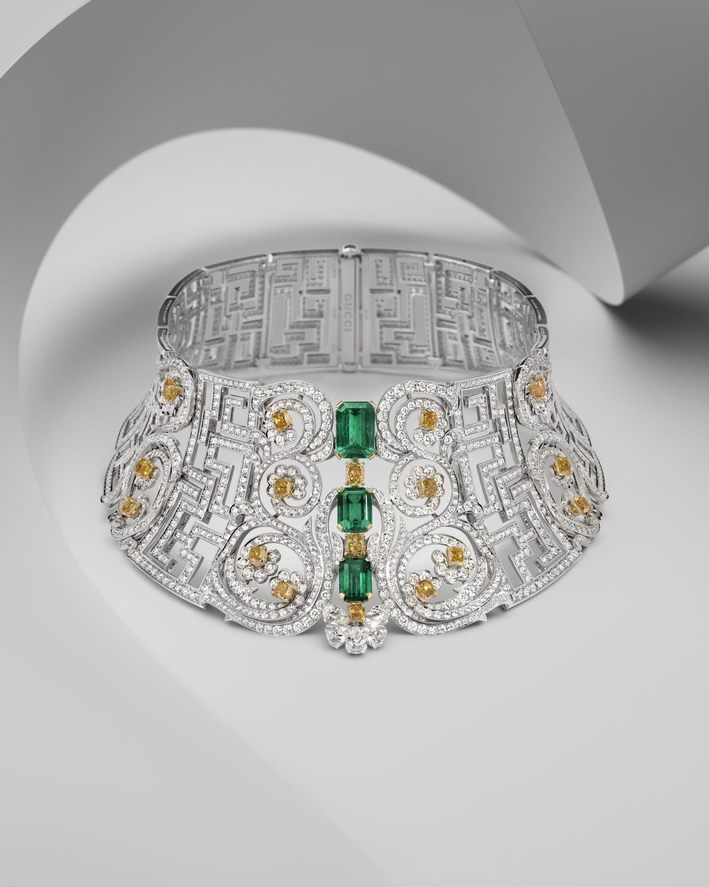 18K白金Choker式鑽石項鏈，鑲嵌祖母綠及黃鑽，拼湊出對稱的迷宮花園圖案，精緻細膩。
