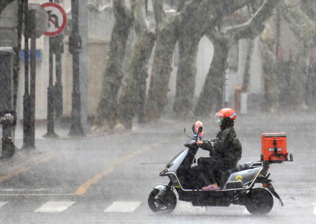 8月10日，外賣騎手冒雨在江蘇蘇州街頭行進。 新華社