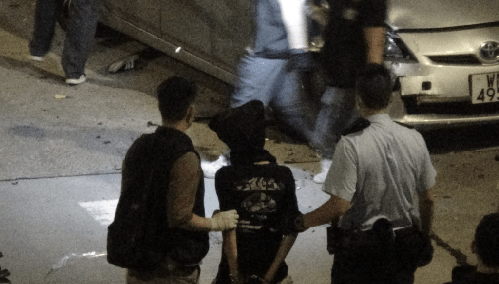 被告被黑布蒙頭，反鎖雙手調查。