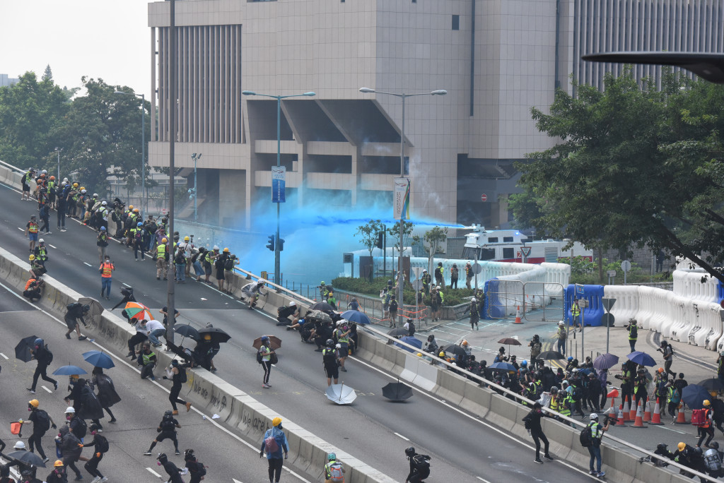 示威者在金鐘進攻總政，大批防暴警發射催淚彈、水炮射水炮驅散人人群。資料圖片