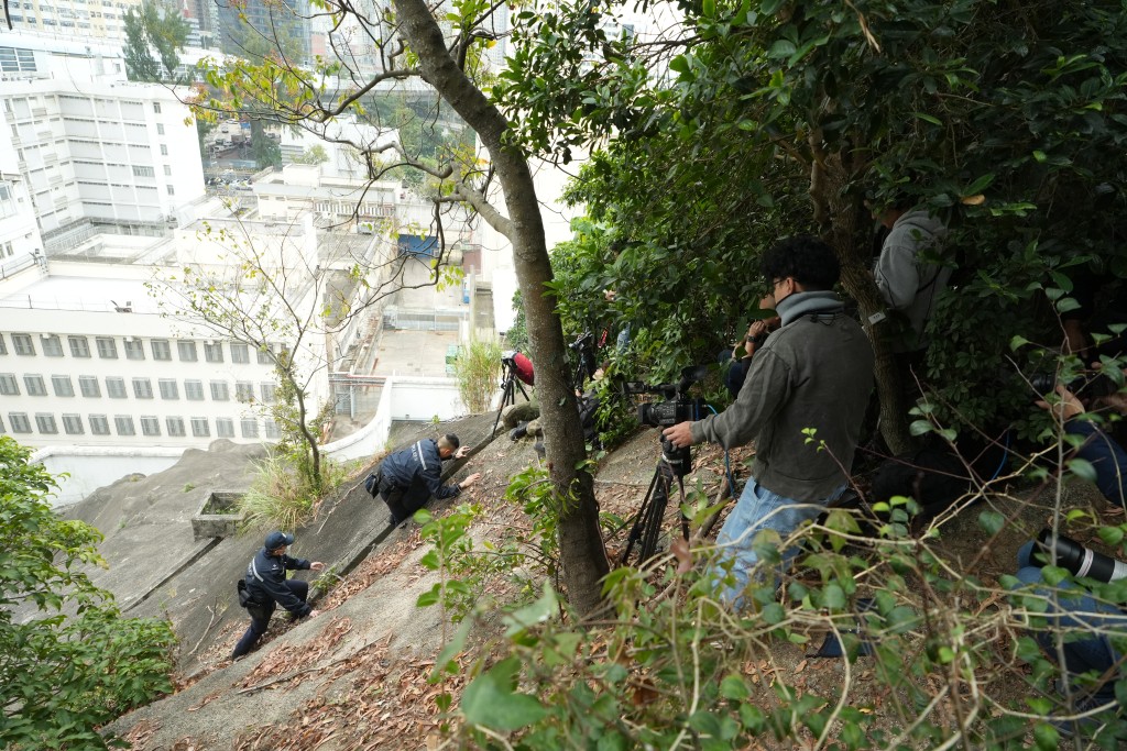 记者今早在茘枝角收押所对开山坡采访拍摄，遭警员查问身份。刘骏轩摄