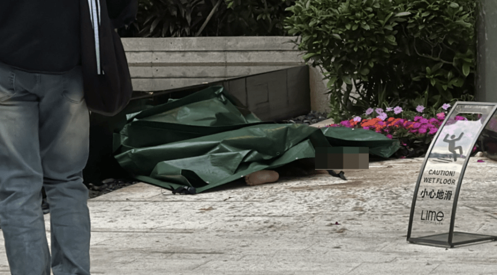 警方以綠色膠布蓋掩男子遺體,正在現場調查男子墮樓原因及經過。蔡楚輝攝 警方以綠色膠布蓋掩男子遺體,正在現場調查男子墮樓原因及經過。蔡楚輝攝