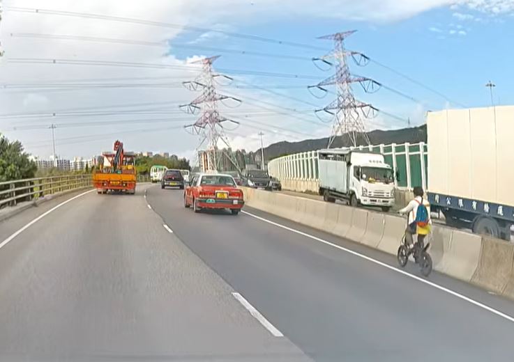 男子驾电动自行车沿元朗公路行驶。fb车cam L（香港群组）影片截图