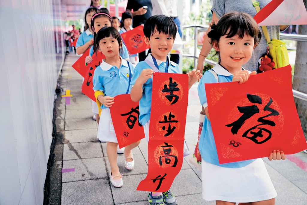 新加坡兒童拿着揮春慶祝農曆新年。