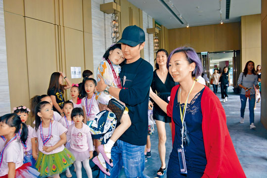 张丹峰抱着女儿，跟老婆洪欣匆匆入场，拒绝受访。